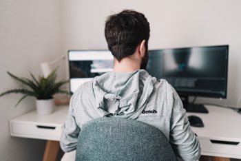 Man working remotely two computer screens